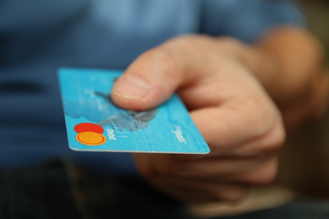 a-person-holding-credit-card